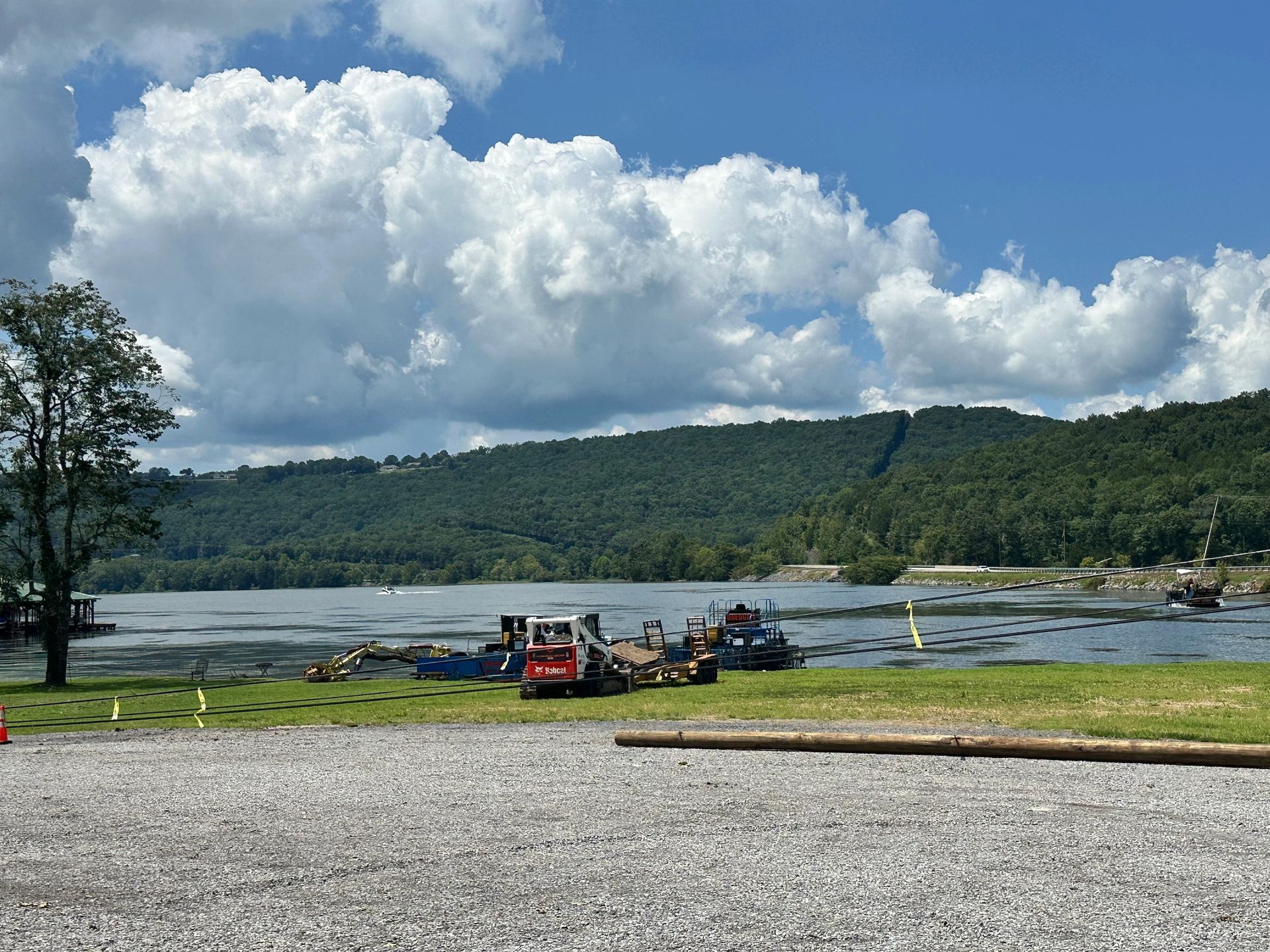 A red truck is parked on the shore of a lake.