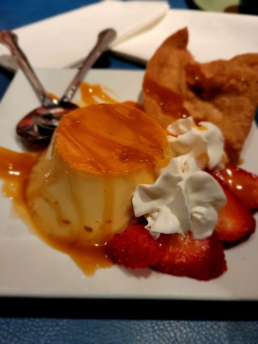 A dessert with whipped cream and strawberries on a plate