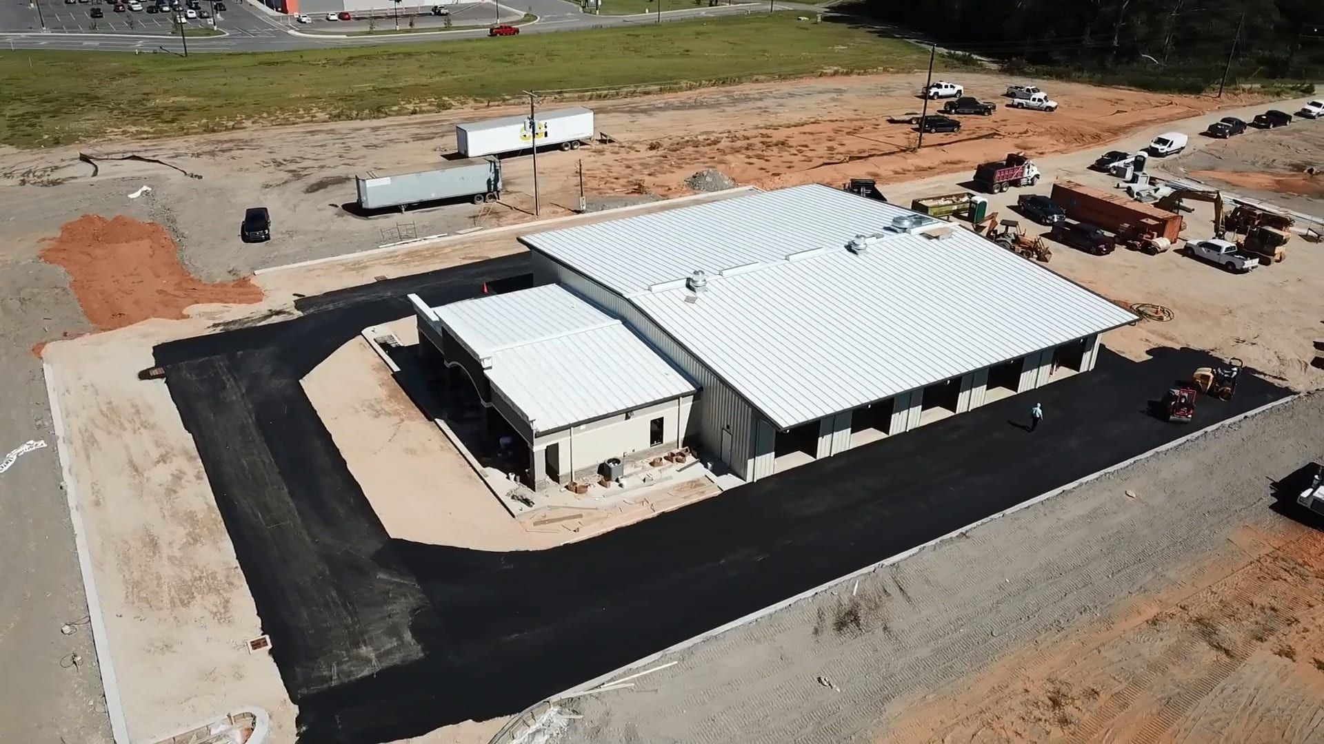 An aerial view of a building under construction in a dirt field.