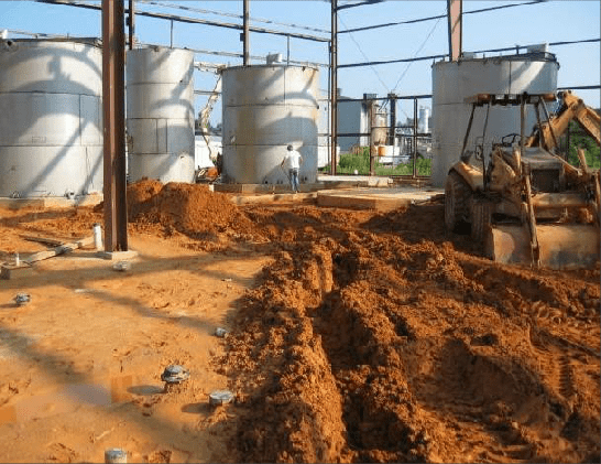 A bulldozer is moving dirt in front of a building