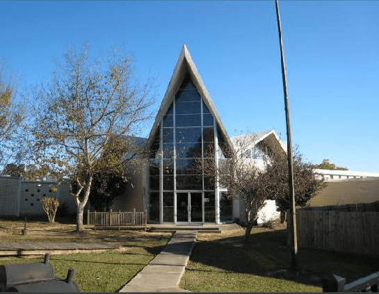 A building with a triangle shaped roof and a lot of windows