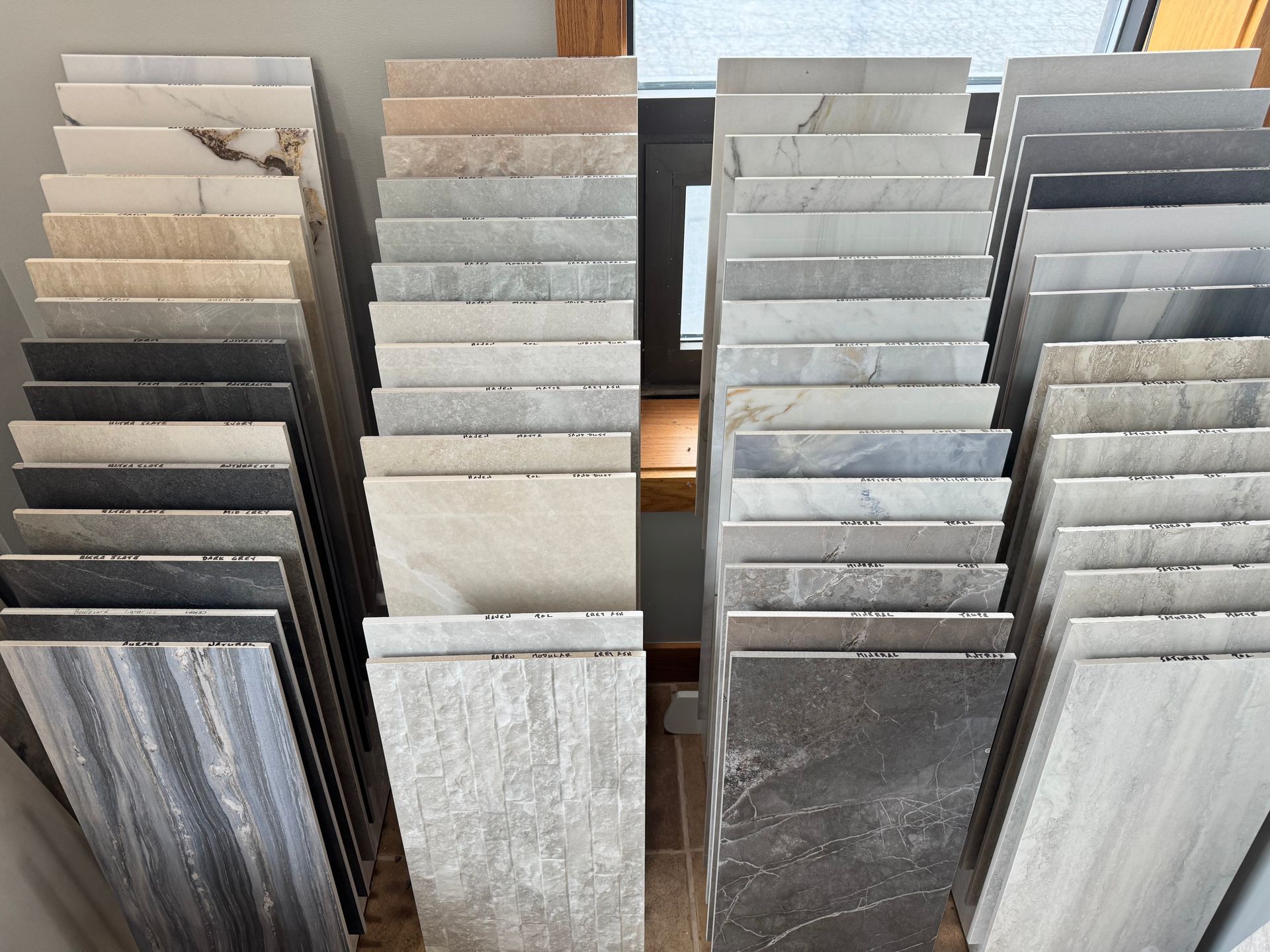 Stacks of various stone tiles in different colors displayed at a store or showroom.