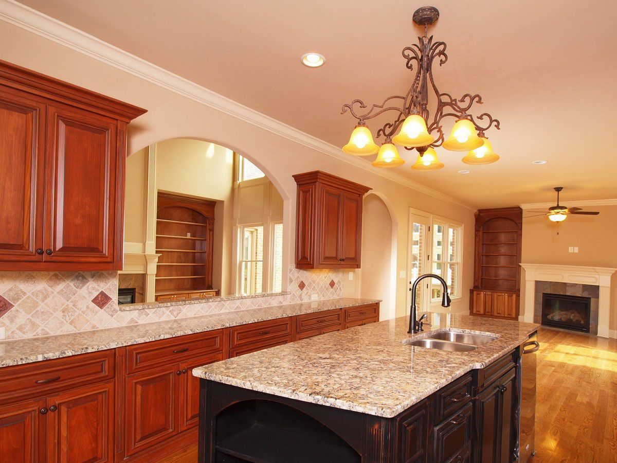 A kitchen with granite counter tops and wooden cabinets
