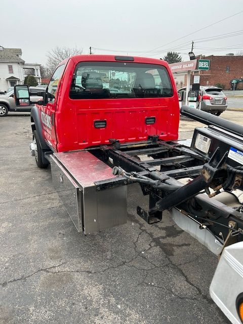 A red tow truck is parked in a parking lot