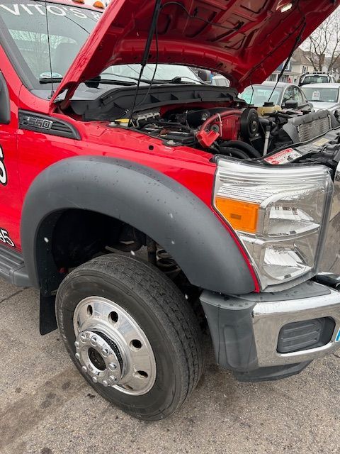 2015 Ford F-550 with the hood up is parked on the side of the road
