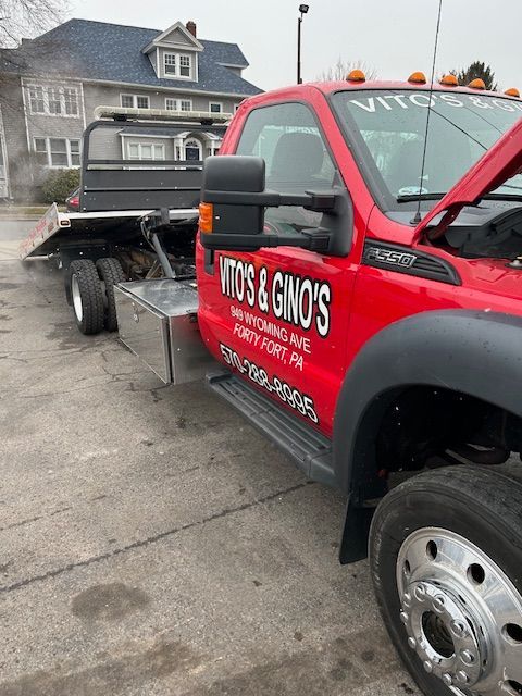 Red tow truck is parked in front of a house