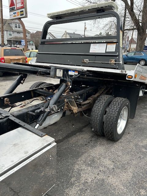 A tow truck is parked in a parking lot next to a gas station