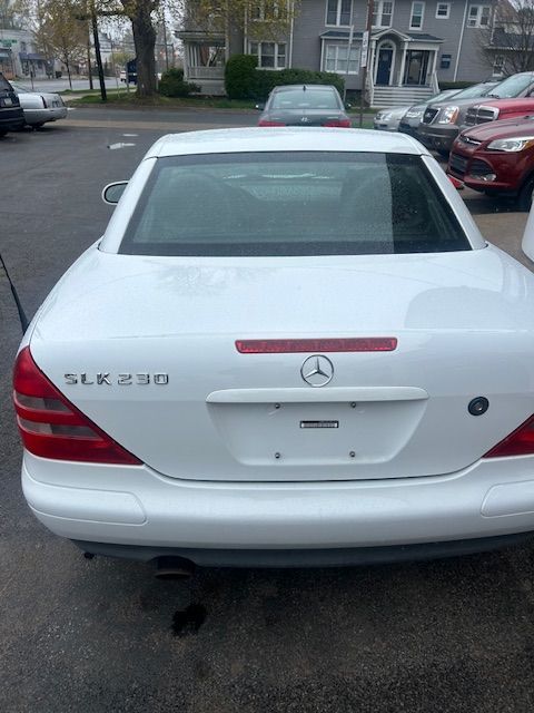 A white mercedes slk 230 is parked in a parking lot