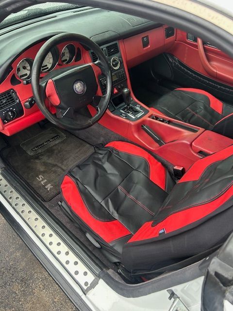 The interior of a white car with red and black seats