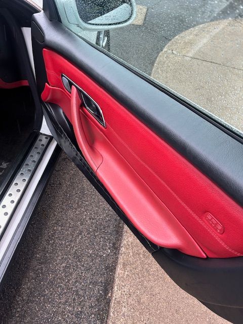 A close up of a red car door with the door open