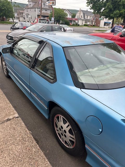 A blue car is parked on the side of the road