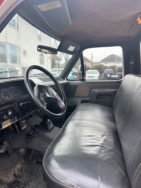 the inside of the 1989 Ford F-450  with a black leather seat