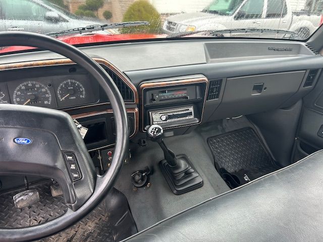 the interior of a 1989 Ford F-450  with a steering wheel and dashboard
