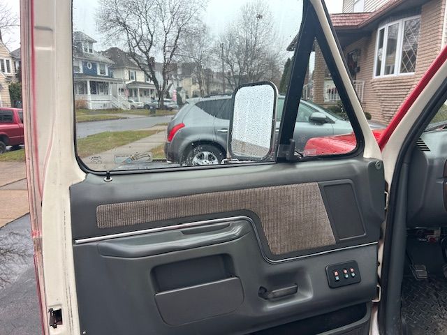 a white truck is parked in front of a house with the door open