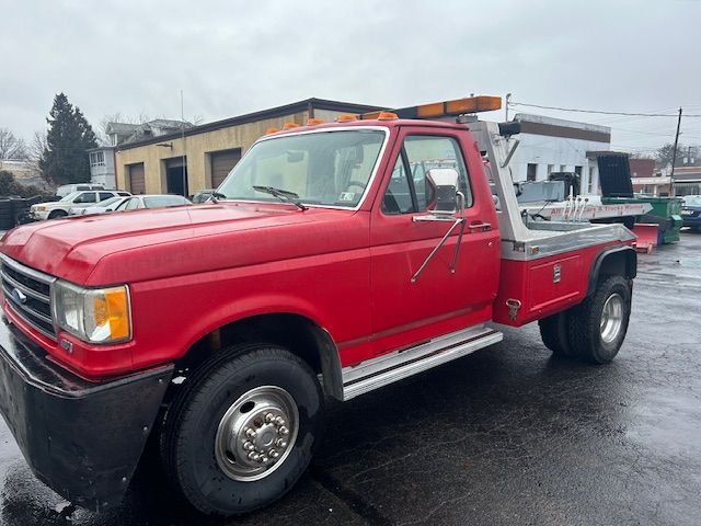 a 1989 Ford F-450  is parked in front of a building