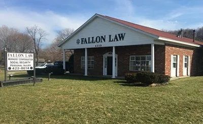 Fallon Law office building with sign, brick facade, and green lawn on a sunny day
