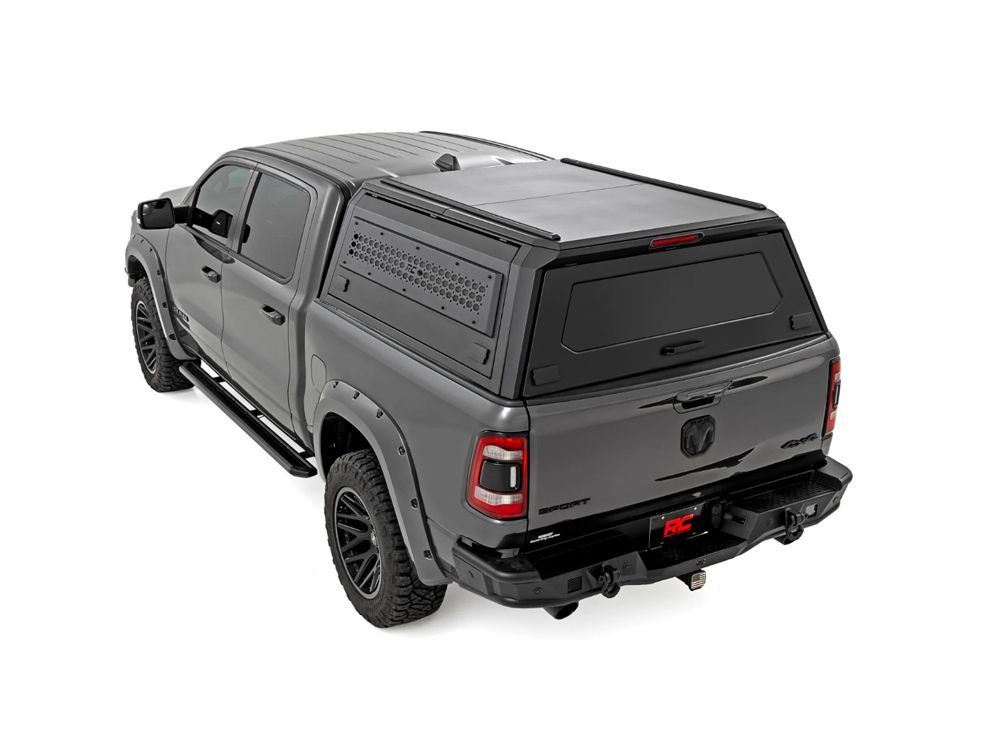 Gray pickup truck with black truck bed cap on white background.