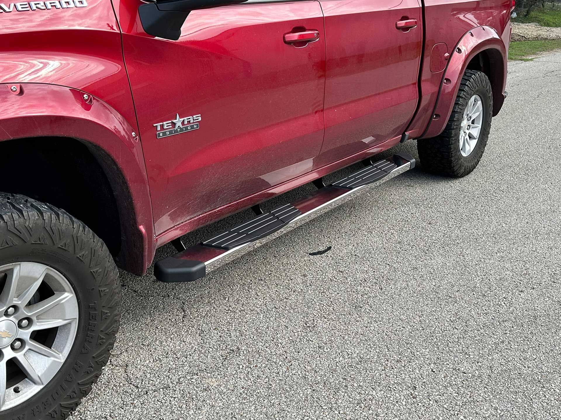 red pickup truck with running boards on gravel