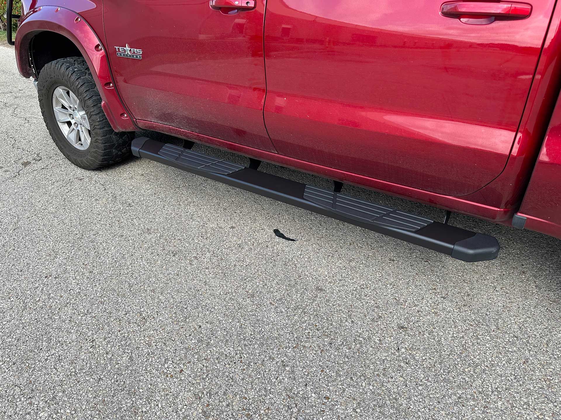 red truck with black running boards on gravel