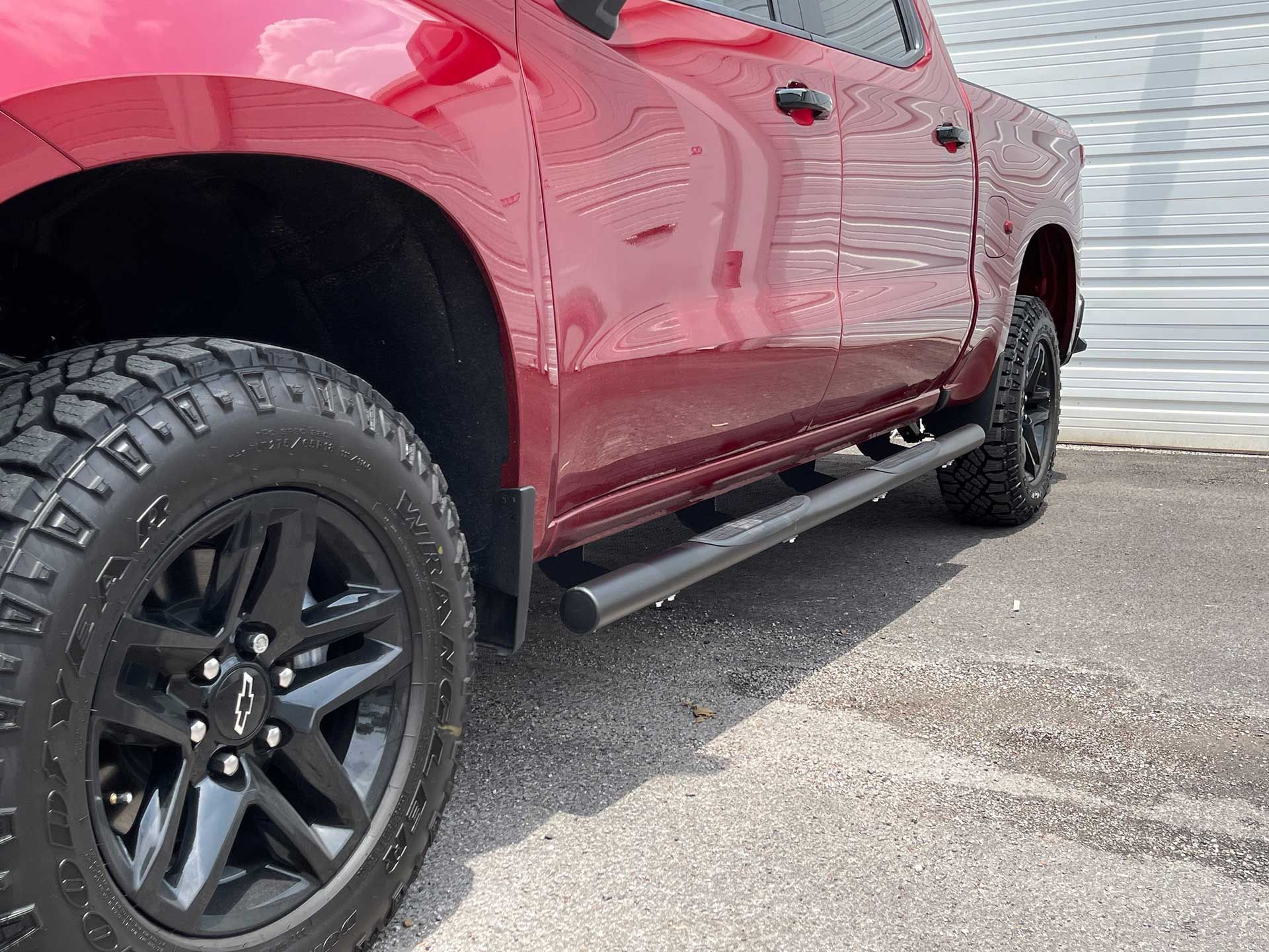 red pickup truck with black wheels and running boards