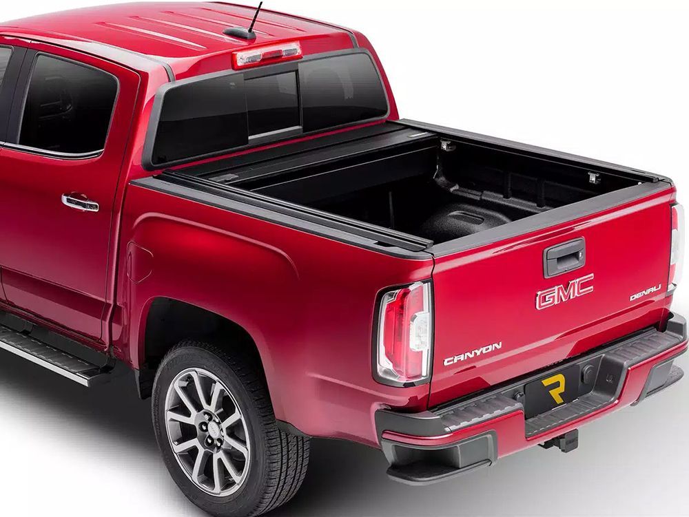 Red GMC Canyon pickup truck with a black bed cover.