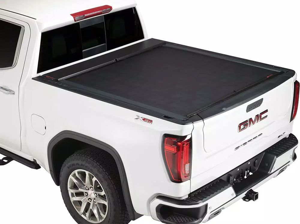 White GMC truck with black retractable tonneau cover.