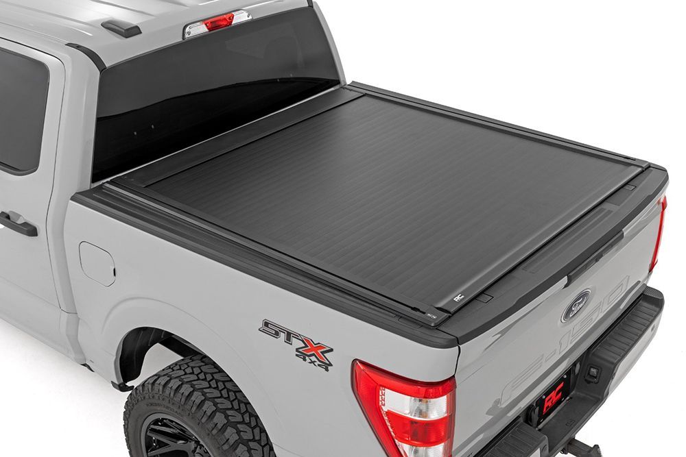 Gray pickup truck with black, retractable bed cover.
