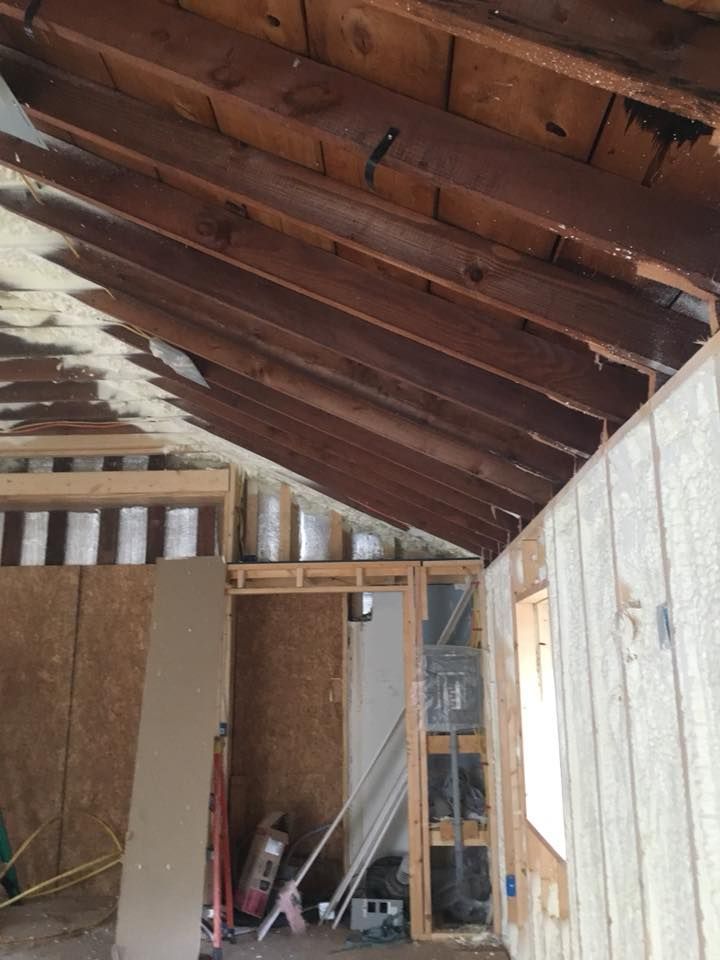 A room with a wooden ceiling and a ladder in it