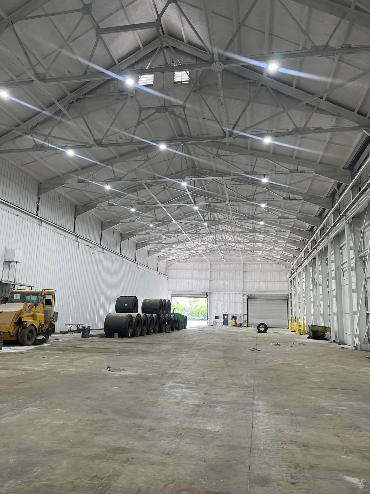 A large warehouse with a lot of trucks parked inside of it.
