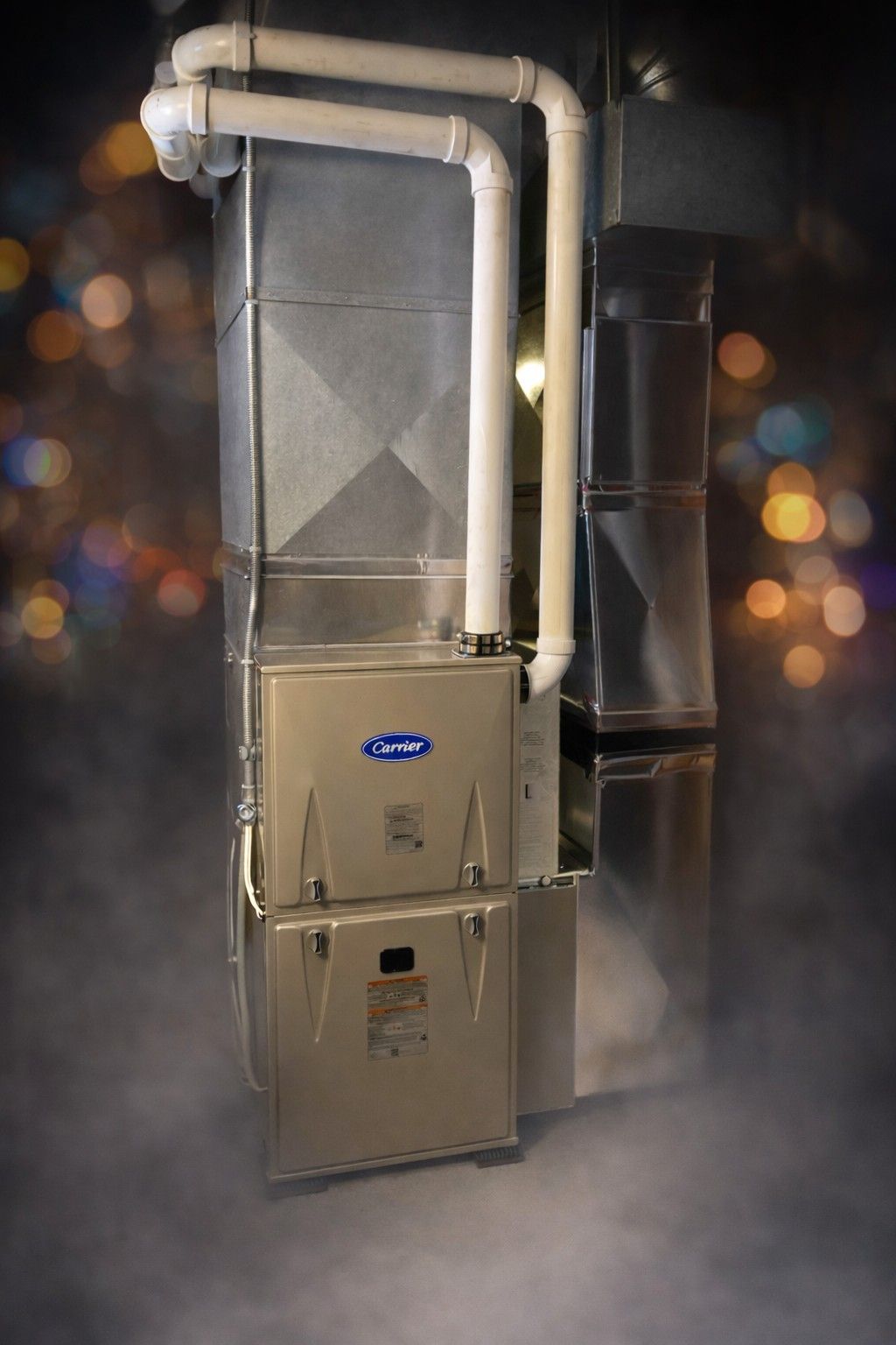 Silver HVAC unit with white ductwork, indoors.