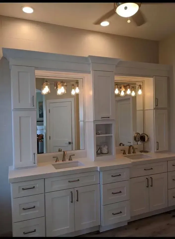 White double vanity bathroom with large mirror, lights, and beige walls