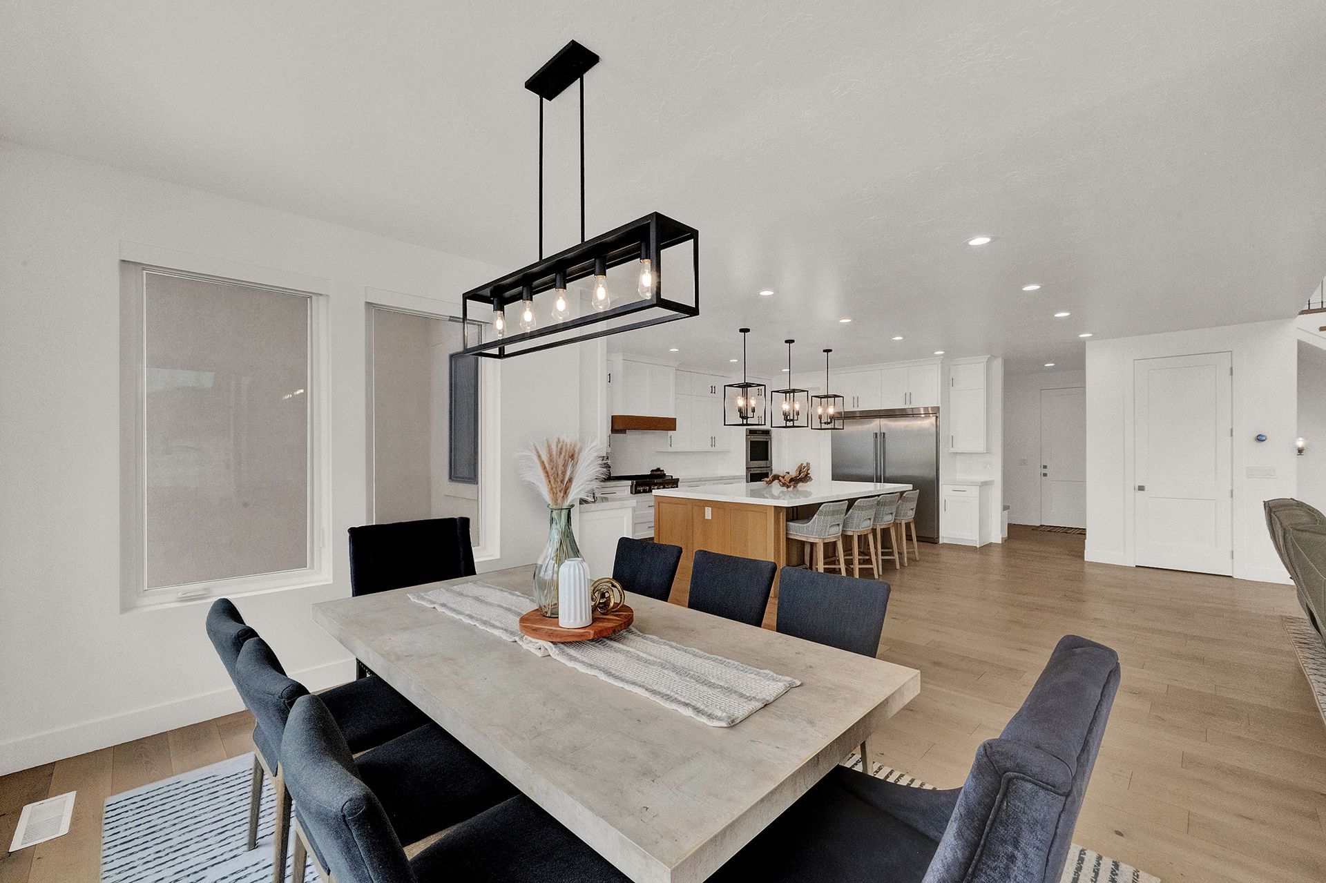 A dining room with a table and chairs and a chandelier hanging from the ceiling.