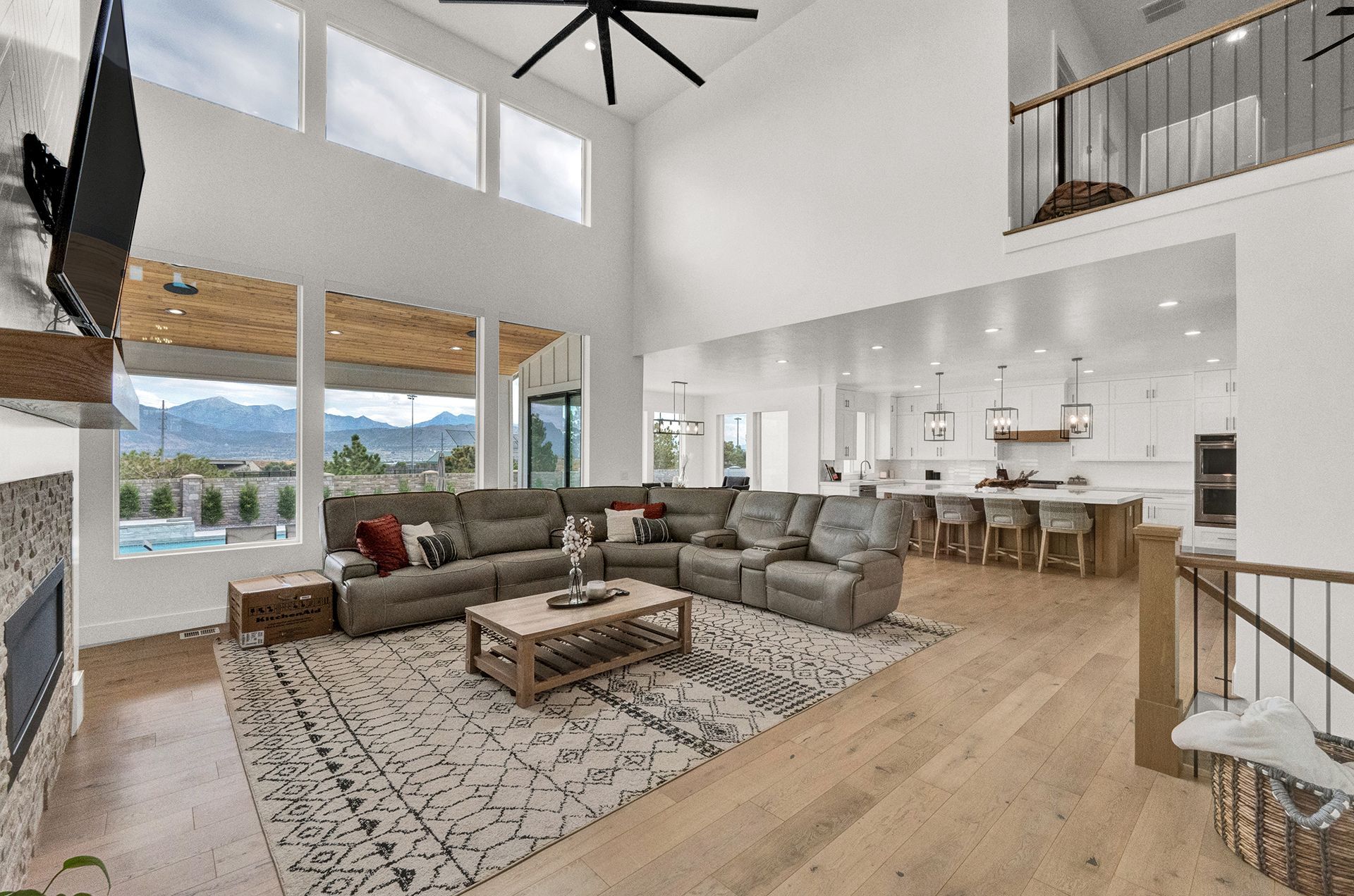 A living room with a large sectional couch , coffee table , fireplace and television.