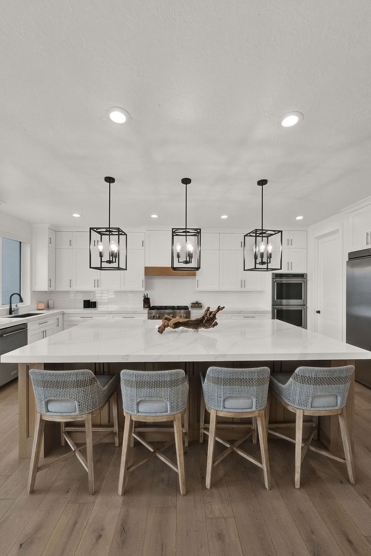 There is a large island in the middle of the kitchen with a table and chairs.