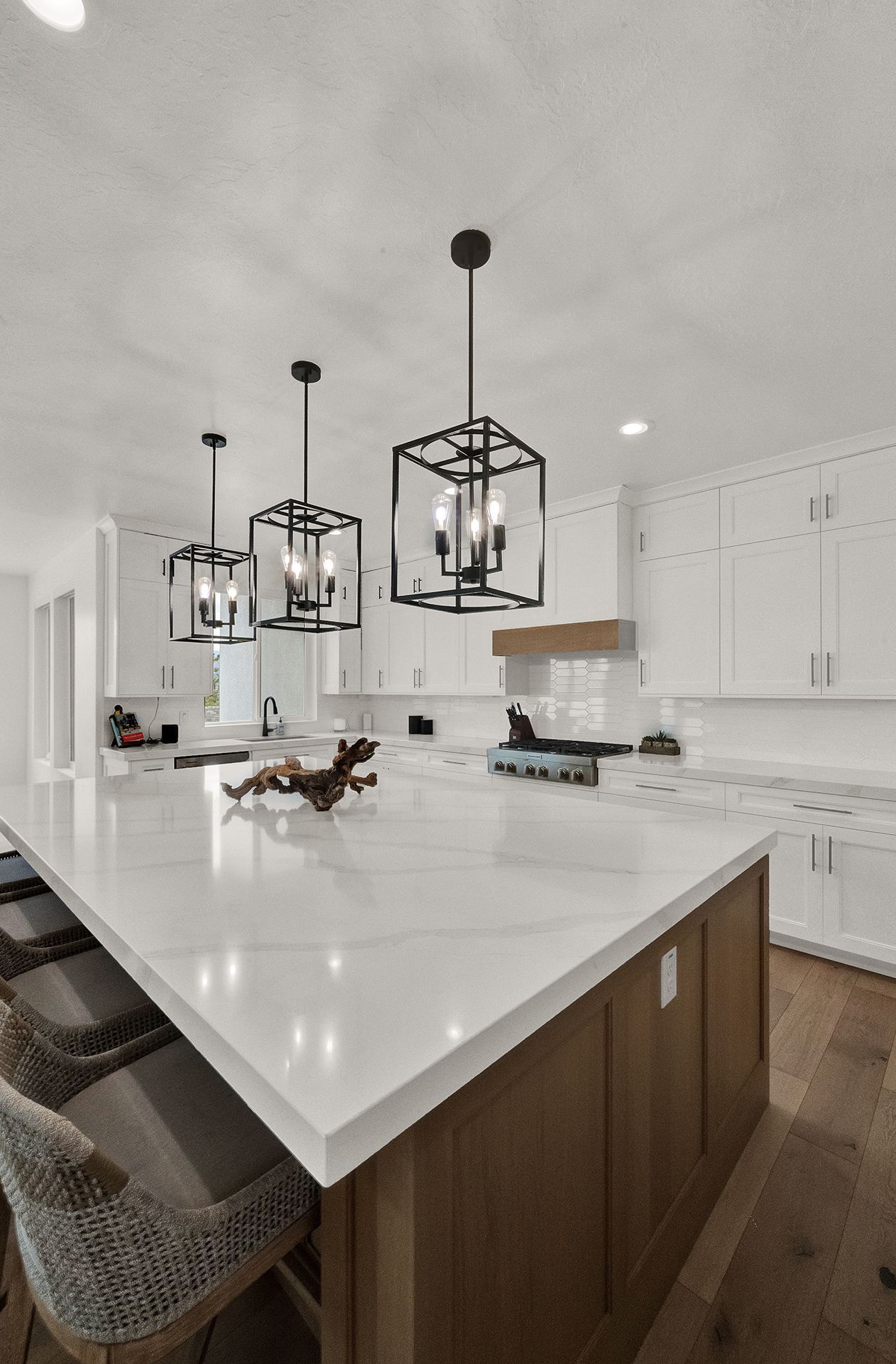 A kitchen with a large island and white counter tops.