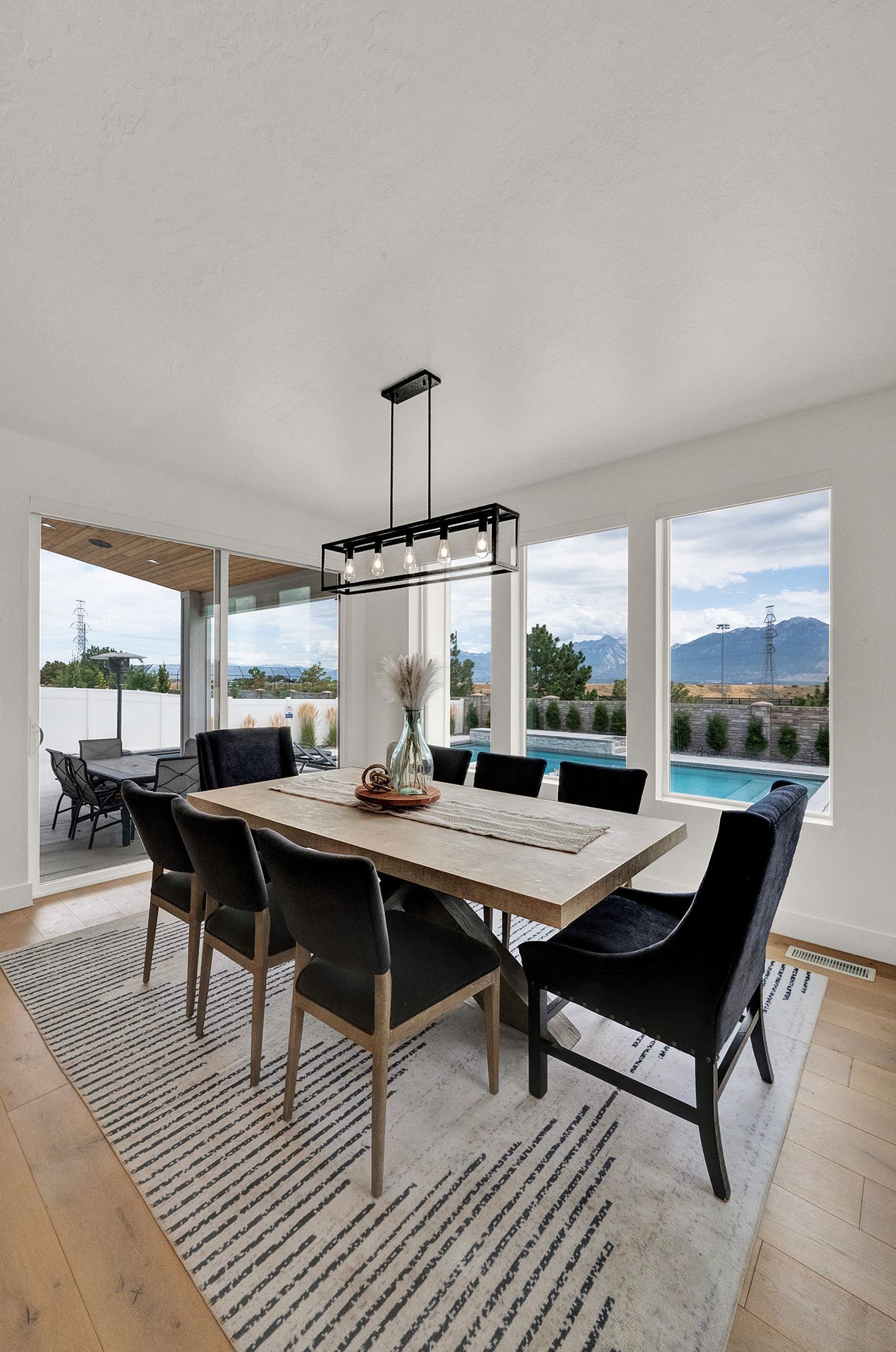 A dining room with a table and chairs and a rug.