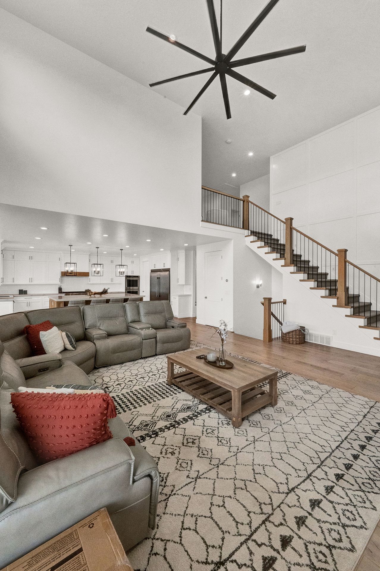 A living room with a couch , chair , coffee table and stairs.