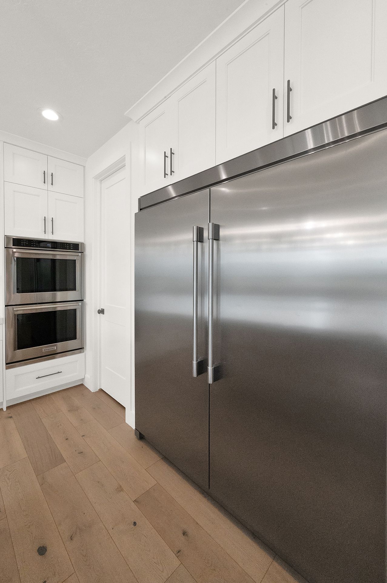A kitchen with stainless steel appliances and white cabinets.