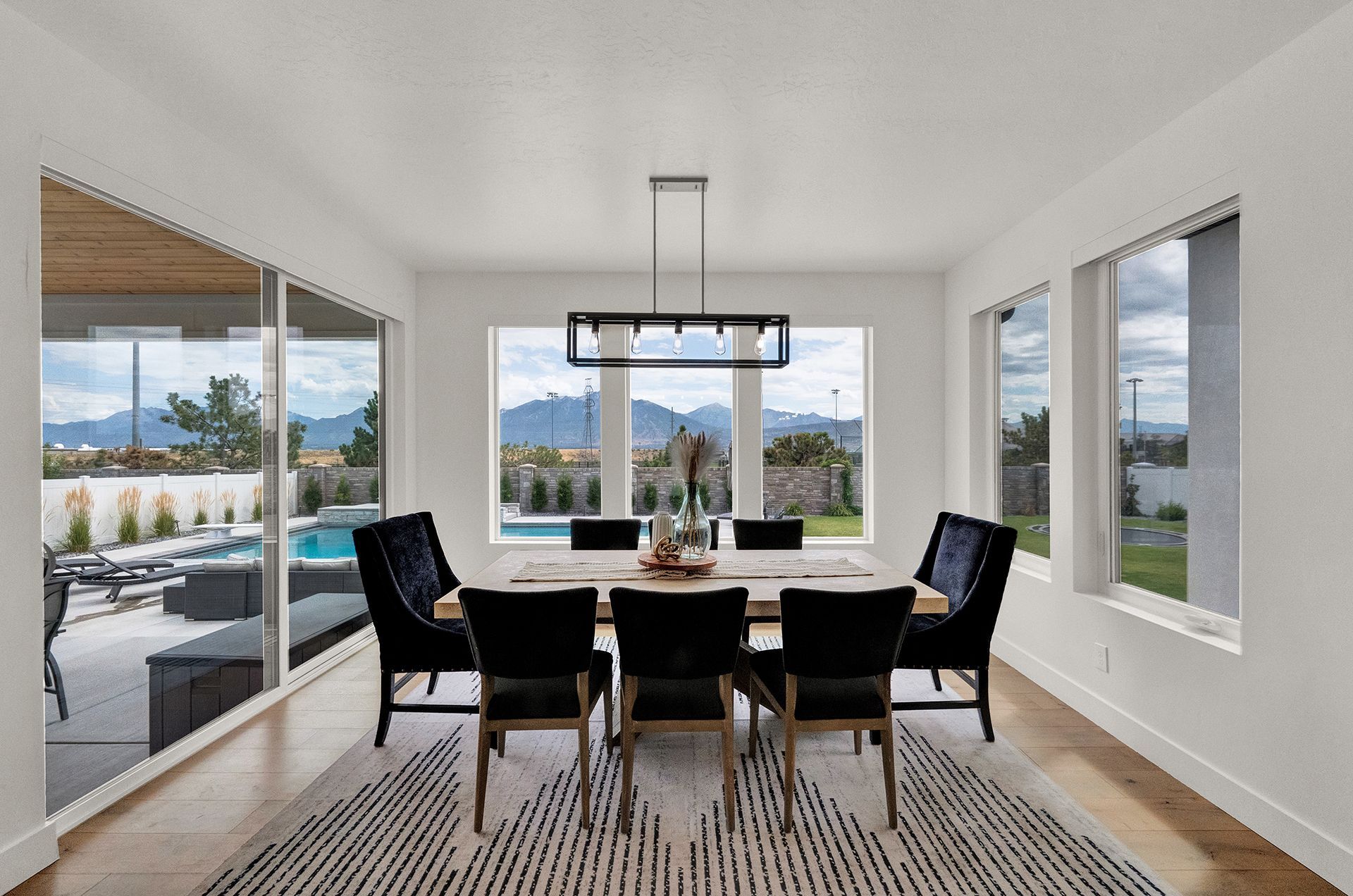 A dining room with a table and chairs and a rug.
