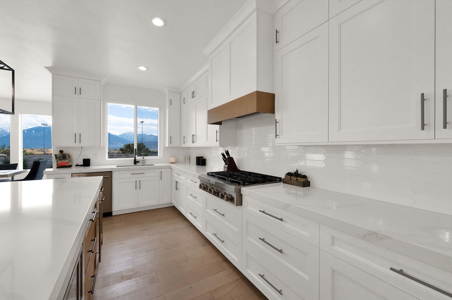 A kitchen with white cabinets , white counter tops , and a stove.