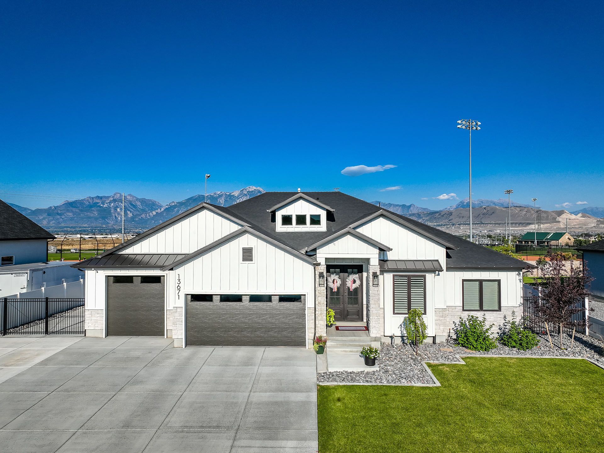 A large white house with a black roof is for sale.