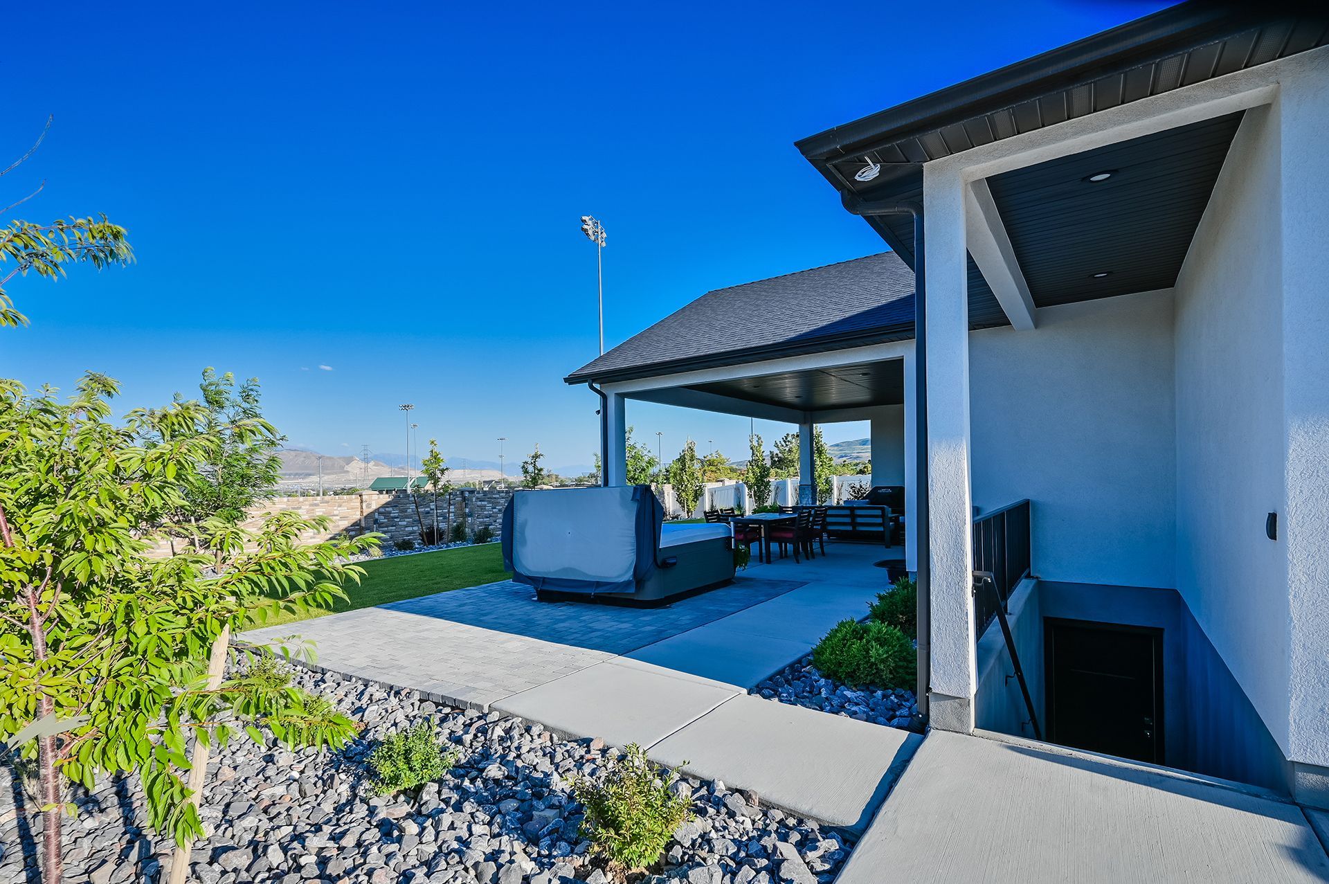 A white house with a covered patio and a hot tub