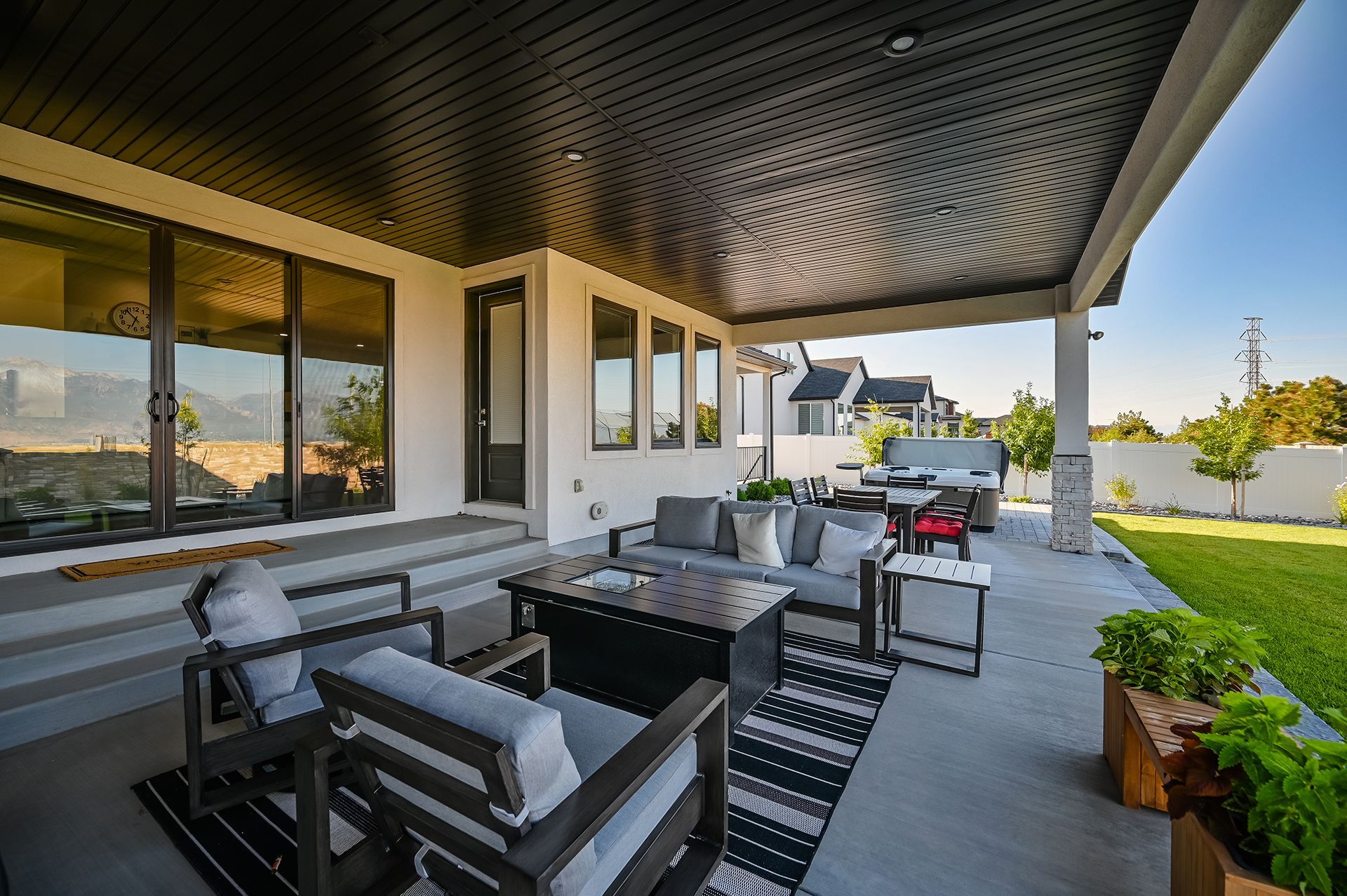 A patio with a couch , chairs , and a table under a canopy.