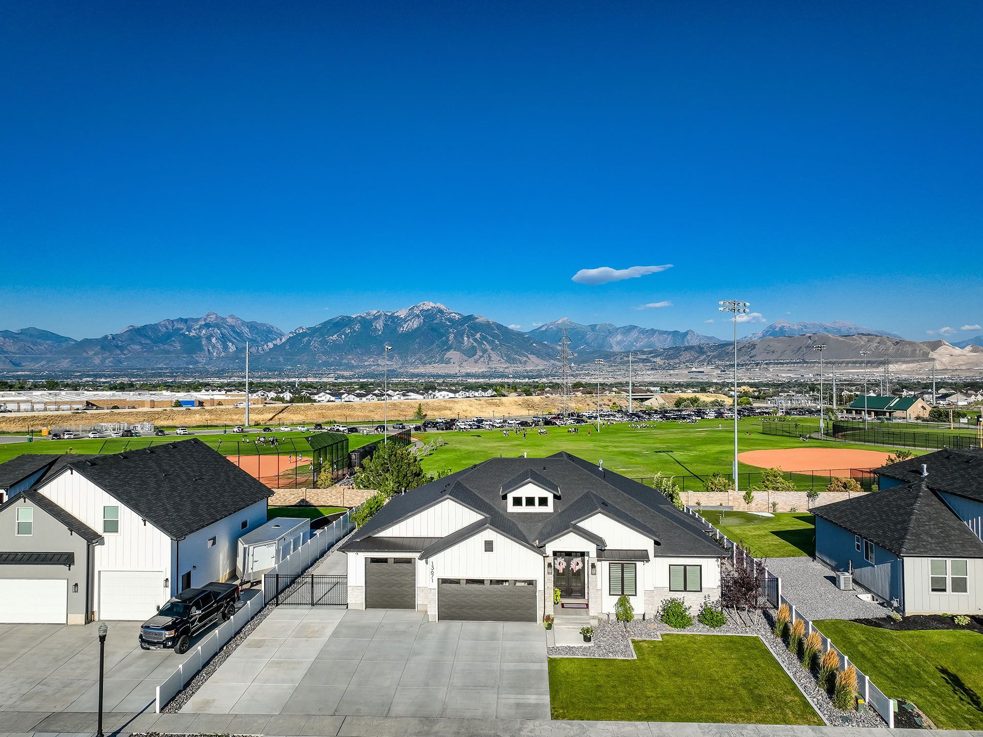 An aerial view of a house in a residential area with mountains in the background.