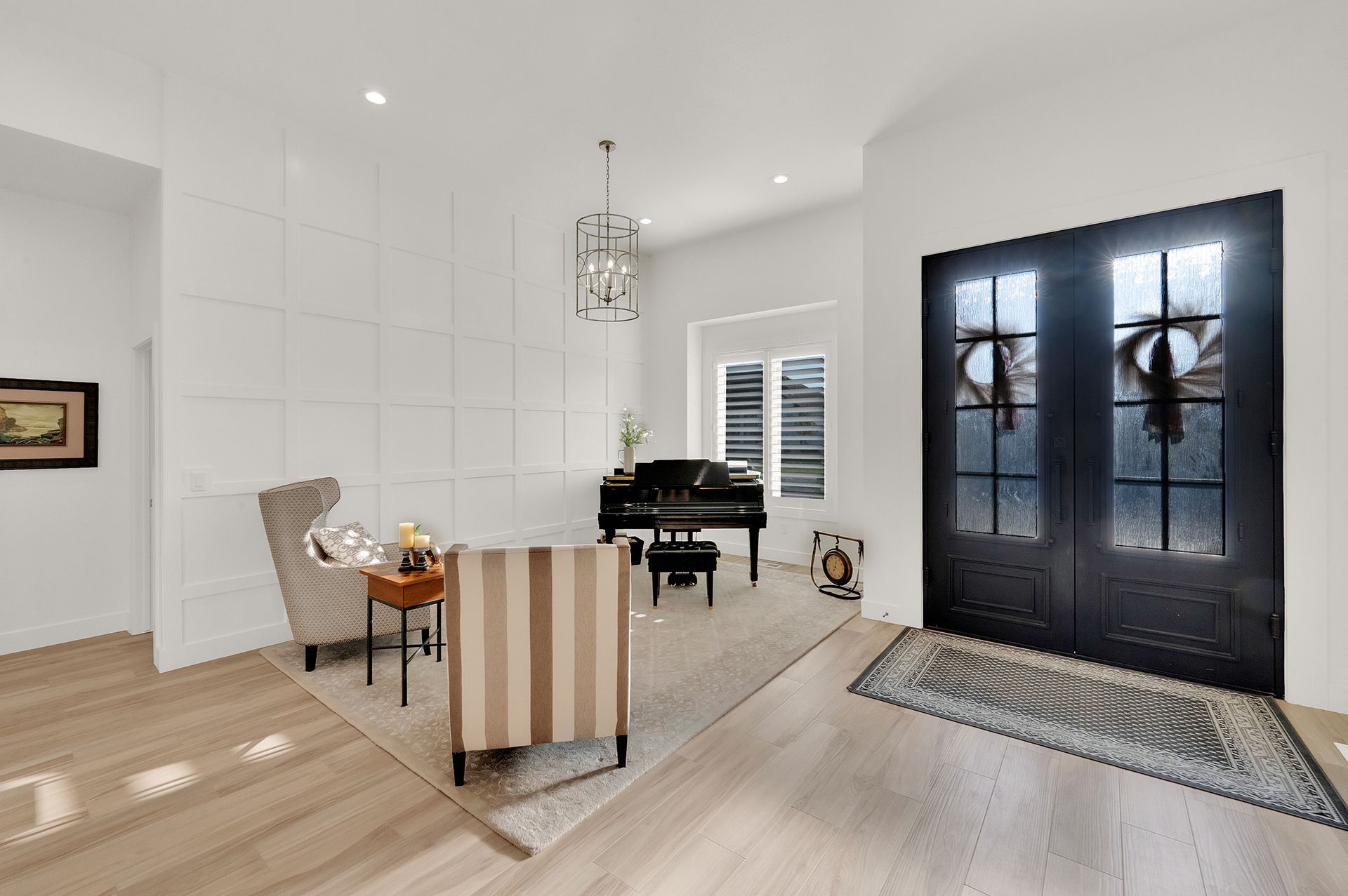 A living room with a piano , chairs , and a rug.