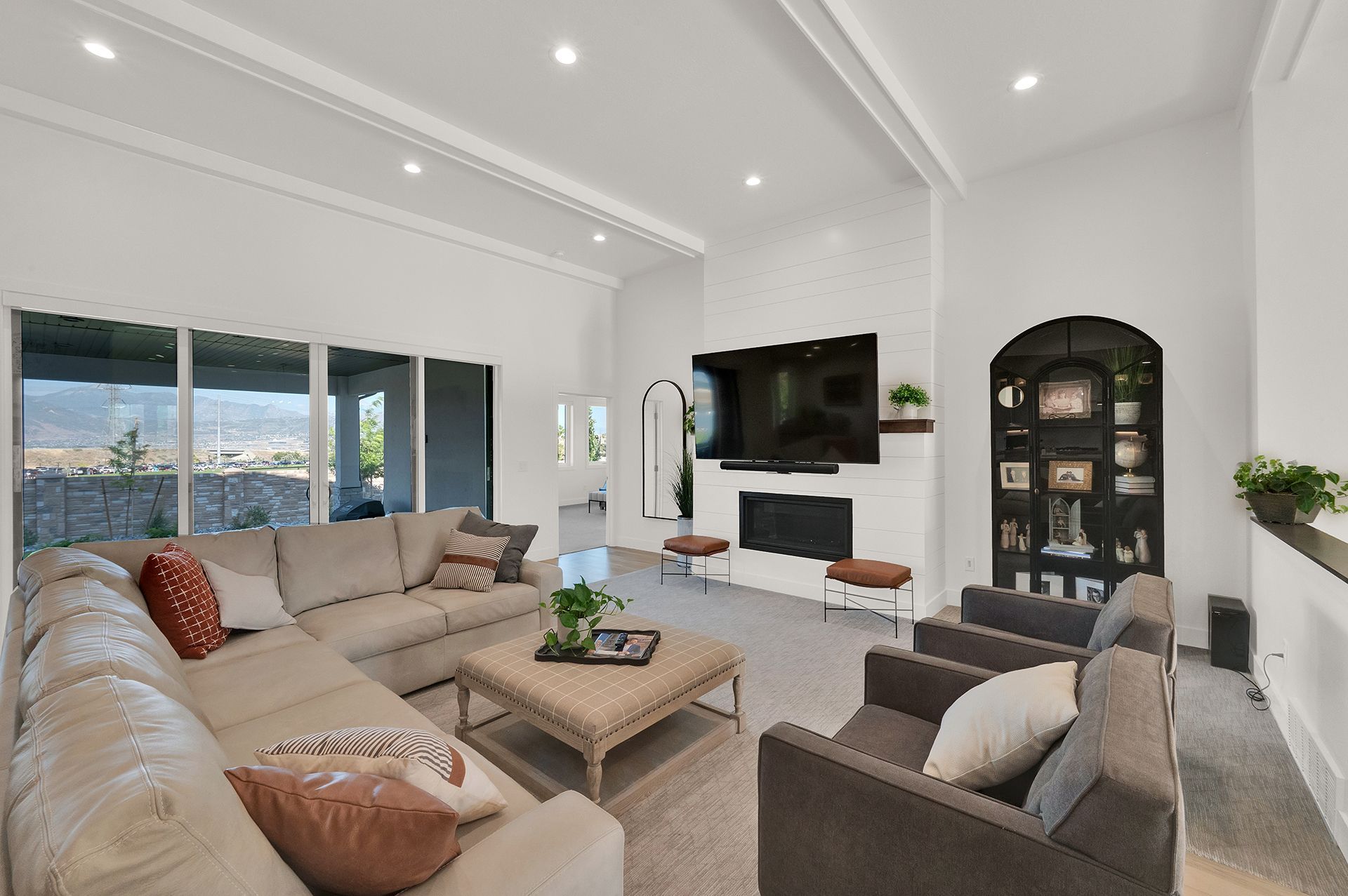 A living room with a couch , chairs , coffee table and television.