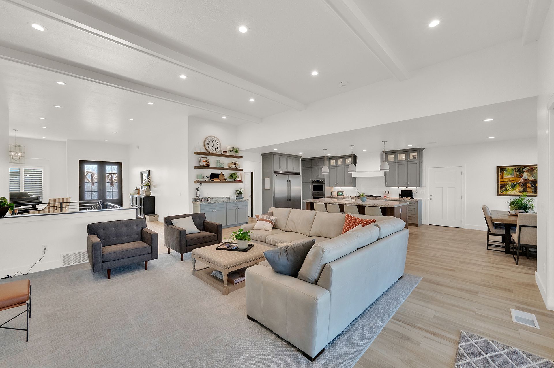 A living room with a large sectional couch and chairs