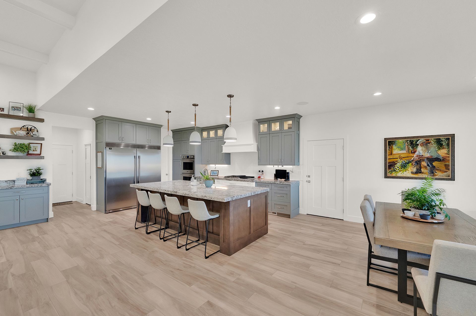 A kitchen with a large island and a dining table.