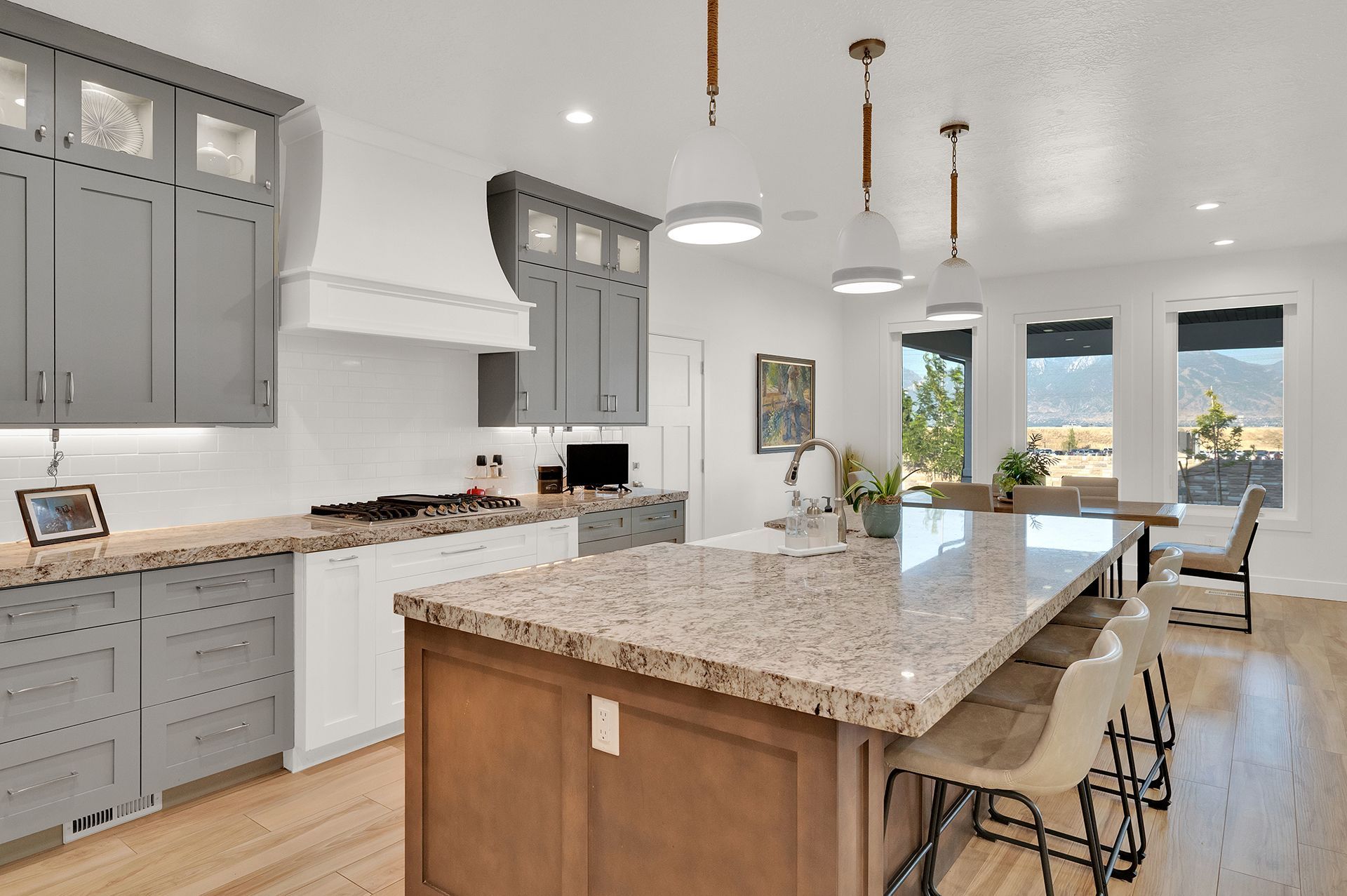 A kitchen with granite counter tops and gray cabinets