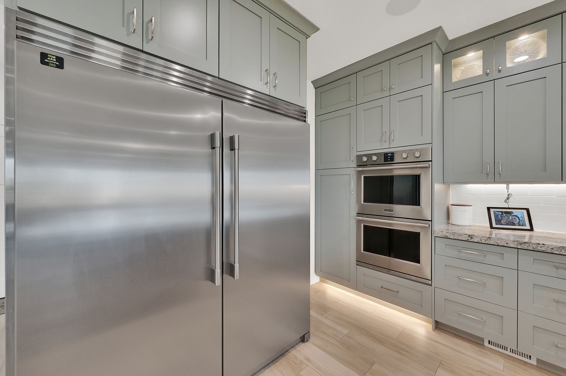 A kitchen with stainless steel appliances and gray cabinets